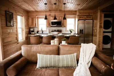 a living room with a couch and a kitchen at The Oak at Middlefork Ridge in Laurelville