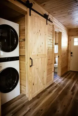 a wooden door in a room with a washer and dryer at The Oak at Middlefork Ridge in Laurelville