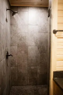 a bathroom with a shower with a glass door at The Oak at Middlefork Ridge in Laurelville