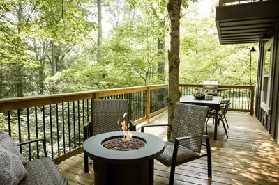 a deck with chairs and a fire pit on a porch at The Oak at Middlefork Ridge in Laurelville