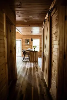 a dining room with a table in a wooden house at The Oak at Middlefork Ridge in Laurelville