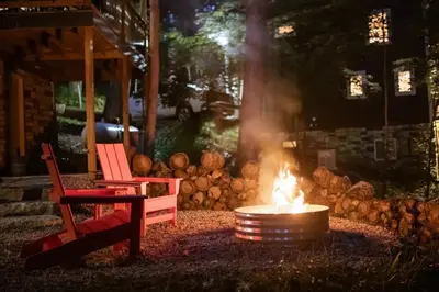 a fire pit with a red chair next to a red chair at The Acorn at Middlefork Ridge in Laurelville
