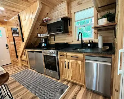 a kitchen in a tiny house with wooden walls at The Acorn at Middlefork Ridge in Laurelville