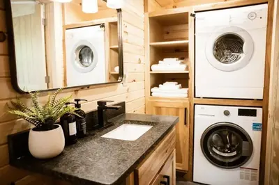 a bathroom with a sink and a washing machine at The Acorn at Middlefork Ridge in Laurelville