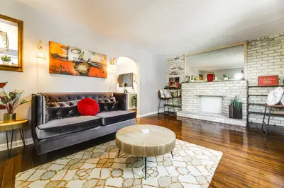 a living room with a black couch and a fireplace at 1 Mi to University of Cincinnati Avondale Gem! in Cincinnati