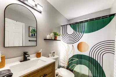 a bathroom with a sink and a mirror at 1 Mi to University of Cincinnati Avondale Gem! in Cincinnati