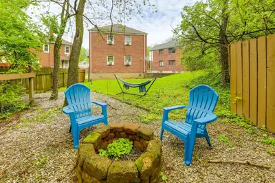 a yard with two blue chairs and a fire pit at 1 Mi to University of Cincinnati Avondale Gem! in Cincinnati