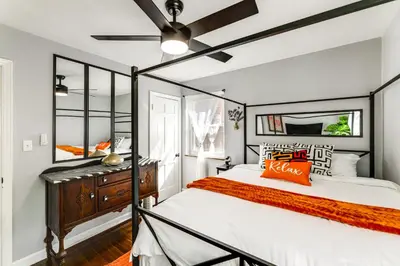 a bedroom with a bed and a ceiling fan at 1 Mi to University of Cincinnati Avondale Gem! in Cincinnati