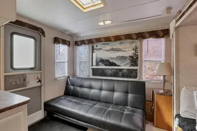 a leather couch in a room with windows at Big Spacious Camper in New Lexington