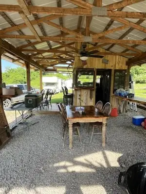 a wooden pavilion with a wooden table and chairs at Big Spacious Camper in New Lexington