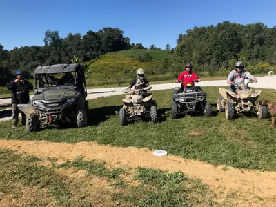 a group of people riding atvs on a dirt road at Big Spacious Camper in New Lexington