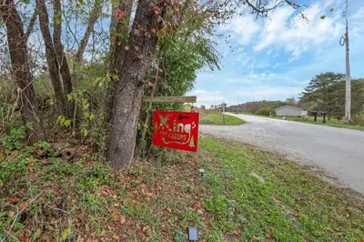 a sign on a tree next to a road at Big Spacious Camper in New Lexington