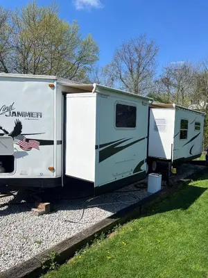 a green and white trailer parked in the grass at Big Spacious Camper in New Lexington