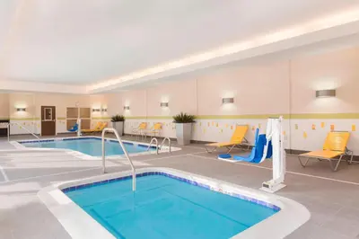 a pool in a hotel room with chairs and a swimming pool at Fairfield Inn & Suites by Marriott Pittsburgh Airport/Robinson Township in Robinson Township