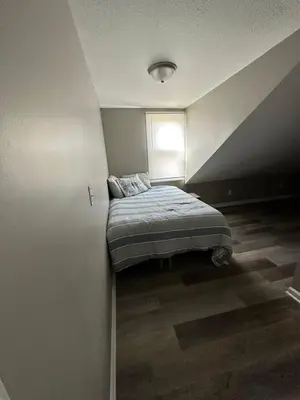 a bedroom with a bed in a room with a window at Off The Hook Vacation Rentals in Put-in-Bay