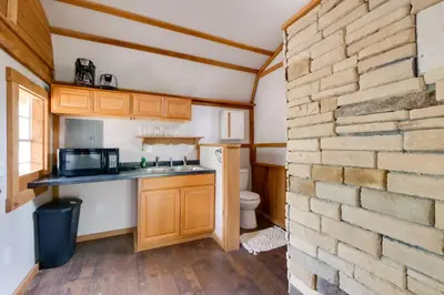 a kitchen with a brick wall and a counter top at Cabin with Trail Access to Mohican River in Brinkhaven