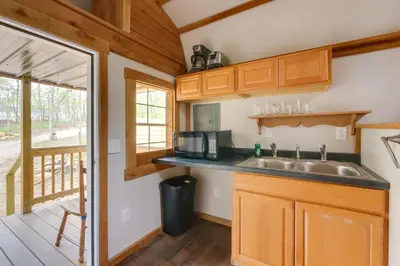 a kitchen with wooden cabinets and a sink at Cabin with Trail Access to Mohican River in Brinkhaven