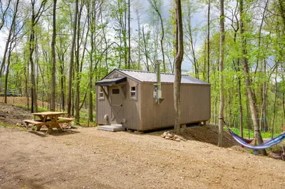 a shed and a picnic table in the woods at On-Site Trails to Mohican River Tiny Home Retreat in Brinkhaven