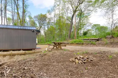 a picnic table and a bench in a field at On-Site Trails to Mohican River Tiny Home Retreat in Brinkhaven