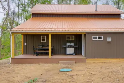 a small house with a table on a porch at 1 Mi to Mohican River Wooded Retreat with Trails! in Brinkhaven