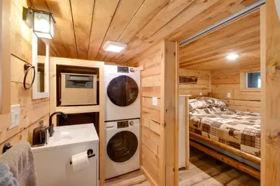 a bathroom with a bed and a sink in a tiny house at 1 Mi to Mohican River Wooded Retreat with Trails! in Brinkhaven