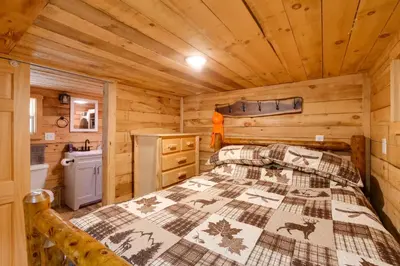 a bedroom with a bed in a wooden cabin at 1 Mi to Mohican River Wooded Retreat with Trails! in Brinkhaven