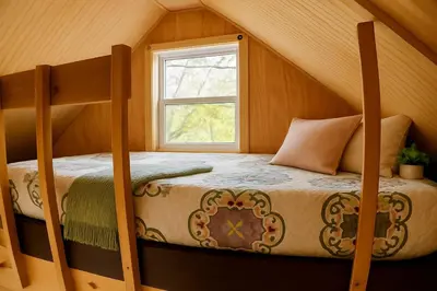 a bedroom with two bunk beds and a window at Enchanting Tree House with a Slide on 200 Acres for a Family Adventure in Germantown, Kentucky in Germantown