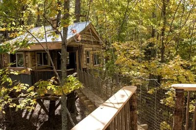 an old house in the woods with a fence at Stunning Tree House Tucked Away Among the Trees near Germantown, Kentucky in Germantown