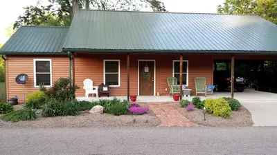 a small house with a green roof and a porch at Woodland Cottage Rental Perfect for Couples Overlooking Raccoon Creek in Ohio in Bidwell