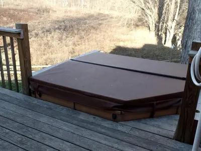 a bed sitting on top of a wooden deck at Woodland Cottage Rental Perfect for Couples Overlooking Raccoon Creek in Ohio in Bidwell