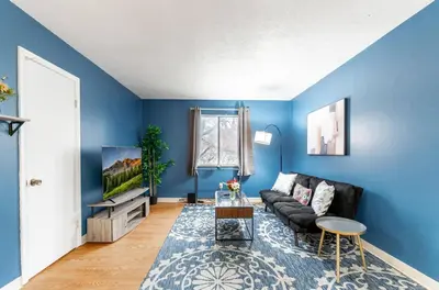 a living room with blue walls and a black couch at OSU - Heart of Short North -STEPS from High ST-OSU in Columbus