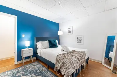 a blue and white bedroom with a bed and a blue wall at OSU - Heart of Short North -STEPS from High ST-OSU in Columbus