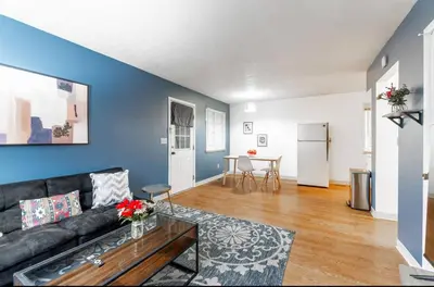 a living room with a black couch and a blue wall at OSU - Heart of Short North -STEPS from High ST-OSU in Columbus