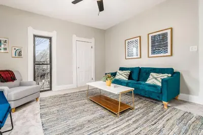 a living room with a blue couch and a table at Short north- STEPS to High St -Private Parking-OSU in Columbus