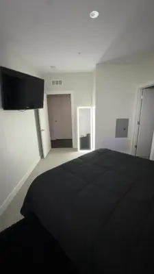 a bedroom with a black bed and a flat screen tv at The 513 Flat! 1BR, 1Bath Apt with Pool and Riverfront View! Free Gated Parking! Only Steps from The banks & Stadiums! in Cincinnati