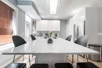 a dining room with a large white table and chairs at Luxury Chefs Kitchen - OSU/Short North - Sleeps 10 in Columbus