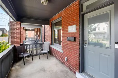 a porch with a door and a bench on it at Luxury Chefs Kitchen - OSU/Short North - Sleeps 10 in Columbus