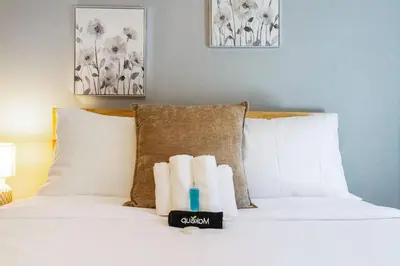 a bed with white pillows and two candles on it at Luxury Chefs Kitchen - OSU/Short North - Sleeps 10 in Columbus