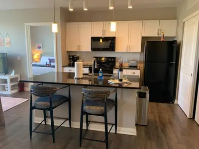 a kitchen with a black refrigerator and two bar stools at The City View Suite Garage Parking Top Floor! in Columbus