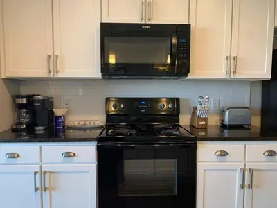 a kitchen with a black stove and a microwave at The City View Suite Garage Parking Top Floor! in Columbus