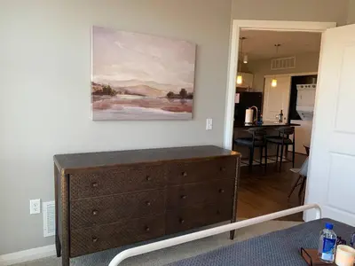 a dresser in a living room with a painting on the wall at The City View Suite Garage Parking Top Floor! in Columbus