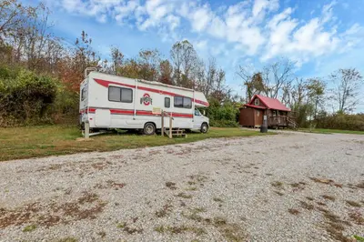 a rv parked next to a building and a shed at RV Camper in New Lexington