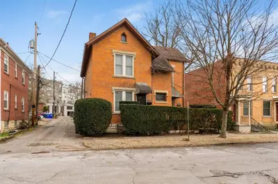 a brick house with bushes in front of a street at Steps 2 High ST - BIG Patio - Private parking- OSU in Columbus