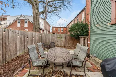 a patio with a table and chairs and a fence at Steps 2 High ST - BIG Patio - Private parking- OSU in Columbus
