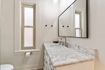 a white bathroom with a sink and a mirror at Steps 2 High ST - BIG Patio - Private parking- OSU in Columbus