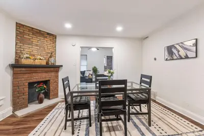 a dining room with a table and chairs and a fireplace at Steps 2 High ST - BIG Patio - Private parking- OSU in Columbus