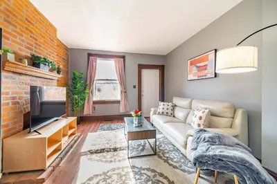 a living room with a couch and a tv at Cozy Brick-Short North Condo - (fenced yard) - OSU in Columbus