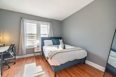 a bedroom with a bed and a desk and a window at Cozy Brick-Short North Condo - (fenced yard) - OSU in Columbus