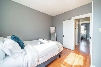 a bedroom with a white bed with a blue stuffed animal on it at Cozy Brick-Short North Condo - (fenced yard) - OSU in Columbus