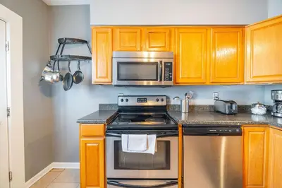 a kitchen with a stove and a microwave at Cozy Brick-Short North Condo - (fenced yard) - OSU in Columbus
